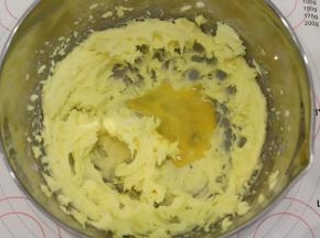 加入一半的全蛋液，打发至蛋液和黄油完全混合均匀。