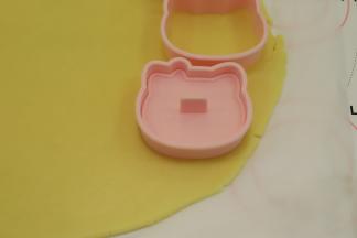 先压上饼干套，再放入印模，轻轻印好图案。