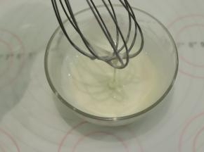 制作糖霜：蛋白粉和水搅拌均匀，筛入糖粉，搅拌至粘稠，滴落呈流线状。