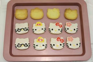 剩余的糖霜分别调成黑色糖霜、粉色糖霜、黄色糖霜、大红糖霜，依次画好眼睛、鼻子、胡须、蝴蝶结，放入密封盒里风干保存。