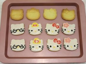 剩余的糖霜分别调成黑色糖霜、粉色糖霜、黄色糖霜、大红糖霜，依次画好眼睛、鼻子、胡须、蝴蝶结，放入密封盒里风干保存。