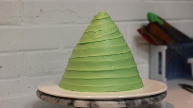 一边用抹刀轻贴奶油表面，一边转动裱花台，旋转向上移动抹刀，做出螺旋状奶油纹路