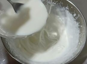 将酸奶吉利丁混合液倒入打发好的淡奶油中