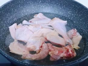 将老母鸡用食品剪刀剪小块，冷水入锅焯水，烧开煮2分钟捞出，用温水将鸡块身上的杂质冲洗干净。