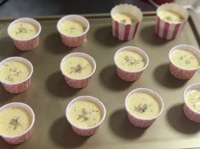 每个蛋糕里放入几粒葡萄干、表面撒上芝麻。