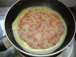 蛋液还没完全凝固时，放入煎好的洋葱饼皮。