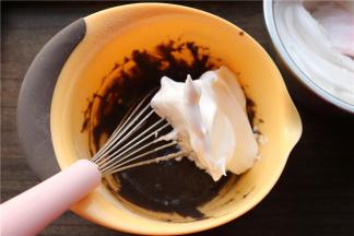 先挖一大勺蛋白霜到蛋黄糊里，用打蛋器不规则搅拌均匀，千万不要画圈。