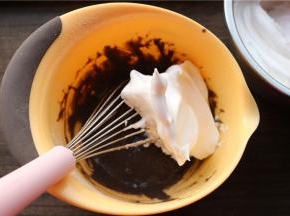 先挖一大勺蛋白霜到蛋黄糊里，用打蛋器不规则搅拌均匀，千万不要画圈。