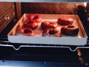 将巧克力贝果放在垫有油纸的烤盘上，入烤箱中层。