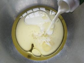 玉米油倒入盆中再倒入牛奶，搅拌至油跟牛奶混合。