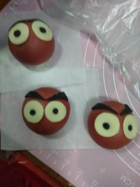 眉毛贴在白色圆圈上面，揉一点黑面团做眼珠