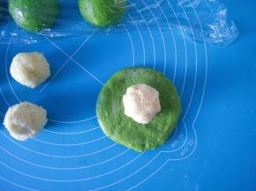 7取一块面团，稍微按压擀薄，放入一个椰蓉馅。