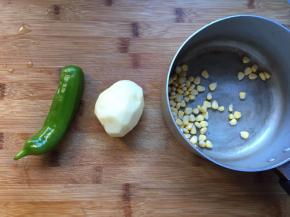 趁面团发酵的时间，做馅料，将玉米用水煮熟，土豆切成片也用热水煮一下，青椒切成丝不用煮，土豆玉米煮好以后，晾干水份