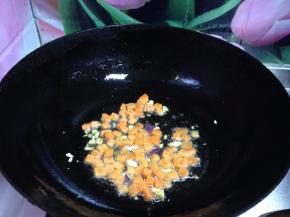热锅凉油下入蒜片炒出香味，下入胡萝卜丁炒至变色