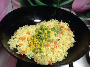 倒入玉米粒和豌豆粒继续炒匀