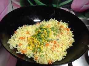 倒入玉米粒和豌豆粒继续炒匀