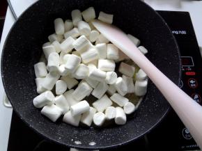 4.黄油全部融化后放入棉花糖，先用刮刀上下翻拌让棉花糖都裹上黄油