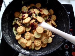 7.加入混合好的饼干然后关火开始用刮刀快速的上下翻拌让棉花糖尽量裹上去