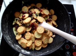 7.加入混合好的饼干然后关火开始用刮刀快速的上下翻拌让棉花糖尽量裹上去