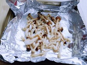 将烫好的菌菇挤干水分，放在锡纸上。