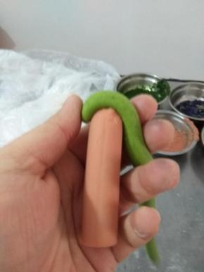 面条横着压住火腿肠一头，然后卷起