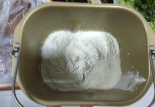 把除果蔬粉以外的材料全部放入面包机，搅拌成光滑的面团