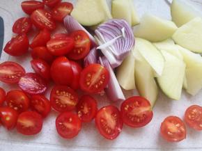 土豆改刀切大拇指大小，滚刀块。洋葱切小。圣女果对切。玉米笋改刀切小。