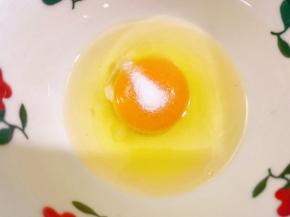 碗里打入一个鸡蛋，加入一小撮盐打散