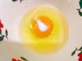 碗里打入一个鸡蛋，加入一小撮盐打散