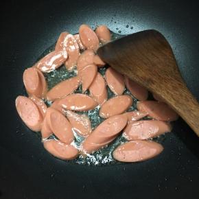 锅中加入油，大火烧热，下入火腿肠煸炒。