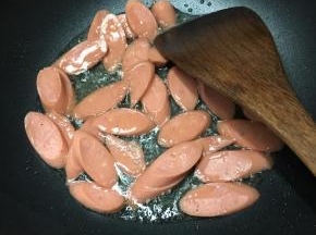 锅中加入油，大火烧热，下入火腿肠煸炒。