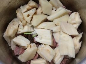 将牛腩，莲藕和刚才准备的配料全部倒入高压锅里。