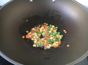 首先放入胡萝卜和豌豆，炒30秒左右。