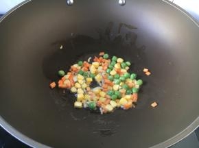 首先放入胡萝卜和豌豆，炒30秒左右。
