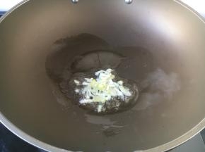 热锅凉油（2勺），放入葱花炒香。