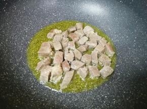 下入牛肉块煸炒至变色。