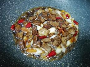 加入两勺红烧酱油和一勺料酒翻炒均匀。