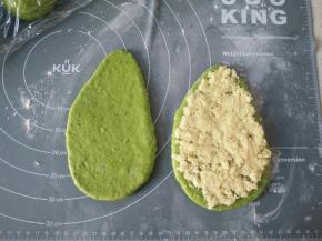 8用擀面杖擀长（如图），再面团上铺好椰蓉馅料，再把另一个面片覆盖在椰蓉上面四周对齐。
