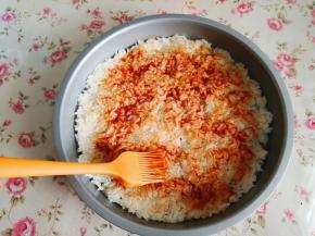 2.	用刷子将番茄酱均匀地涂抹在米饭上，