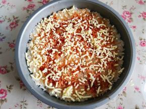 3.	取一部分马苏里拉芝士撒上刷了番茄酱的米饭上，大约70克左右，