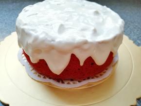 将戚风蛋糕胚放在蛋糕板上，随意涂抹上打发好的奶油，使边缘呈现“积雪”状。