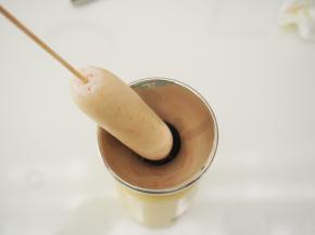 将蛋卷机中的食材轻轻搅匀，用竹签串住秘鲁飞鱼籽肠，放入蛋卷机中启动即可