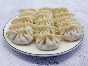 拿一个饺子皮、加肉末在饺子皮中间、依次包成褶子。