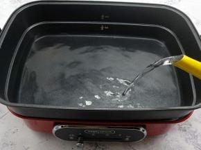 多功能锅里用深锅来蒸饺子，加上清水，水位加到蒸锅这个水位线的一半。