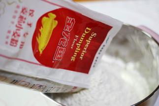 金龙鱼饺子粉倒入大的容器中