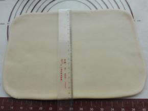 将揉好的面团，用擀面杖将其擀成长方形面片，宽度约20CM，如图所示。