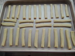 切好的长条，依次先摆放到烤盘中，彼此间隔出一定的距离，并将其盖好保鲜膜进行醒发20分钟，如图所示。