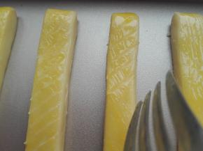 将其晾干后，继续在其表面上刷上一层蛋黄液，同时用叉子在其表面斜着划出图案，如图所示。