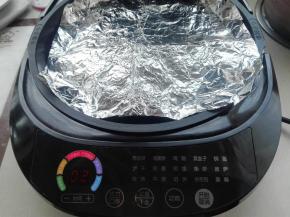 表面再加盖上一张锡纸，如图所示，然后盖好电饼铛了进行烤制即可。