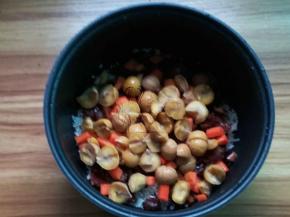 大米淘洗放入电饭煲，加入香菇栗子腊肠，胡萝卜和栗子